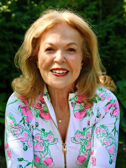 Portrait of Dr. Elaine Dembe smiling in a floral top